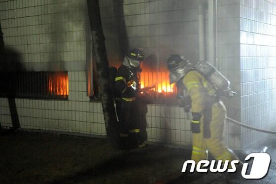 본문 이미지 - 소방관들이 불이 난 마트 안을 살펴보고 있다./최창호 기자© News1  