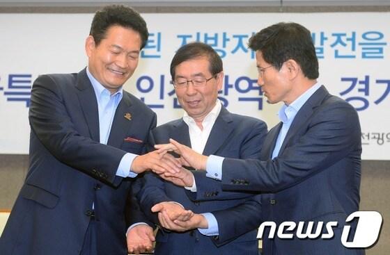 본문 이미지 - 박원순 서울시장과 송영길 인천시장, 김문수 경기도지사가 19일 오전 서울 중구 프레스센터에서 3개시 도지사 공동 무상교육 국고보조금 상향 공동 합의문을 발표한 후 서로 손을 모으고 있다. 3개시 도지사는 무상교육 국고보조율 상향조정 영유아보육법 개정 을 국회 정부에 강력하게 촉구했다. 2013.6.19/뉴스1 © News1   손형주 기자