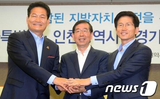 본문 이미지 - 박원순 서울시장과 송영길 인천시장, 김문수 경기도지사가 19일 오전 서울 중구 프레스센터에서 3개시 도지사 공동 무상교육 국고보조금 상향 공동 합의문을 발표한 후 서로 손을 모으고 있다. 3개시 도지사는 무상교육 국고보조율 상향조정 영유아보육법 개정 을 국회 정부에 강력하게 촉구했다. 2013.6.19/뉴스1 © News1   손형주 기자
