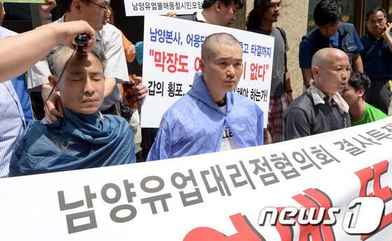 본문 이미지 - 남양유업대리점협의회 회원들이 19일 오후 서울 중구 남대문로 남양유업 본사 앞에서 결사투쟁을 알리는 긴급 기자회견 후 삭발식을 하고 있다. 왼쪽부터 협의회 정승훈 총무, 이창섭 회장, 최근홍 회원. 2013.6.19/뉴스1 © News1 양동욱 기자