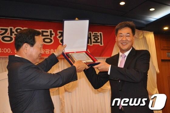 본문 이미지 - 19일 오후2시 춘천베어스호텔에서 열린 2013 새누리당 도당대회에서 위원장으로 선출된 정문헌 의원(오른쪽)이 한기호 의원(왼쪽)에게 공로패를 전달받고 있다© News1 홍성우 기자  