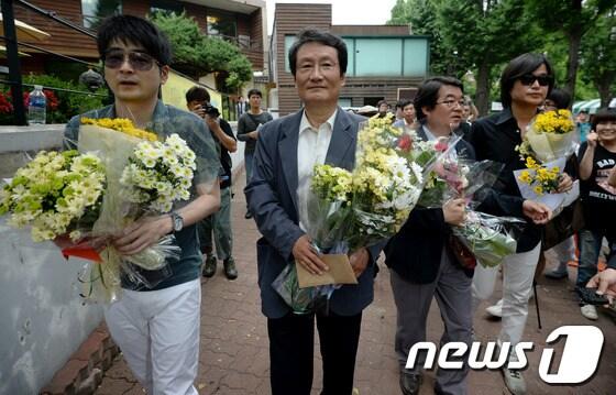 본문 이미지 - 20일 오후 서울 삼청동 청와대 인근에서 탁현민 교수, 문성근 전 민주당 상임고문, 안도현 시인, 주진우 시사IN 기자 등이 국정원 게이트 및 검찰의 표적수사 항의 긴급성명발표 후 성명서와 꽃다발을 청와대 민원실에 제출하기 위해 이동하고 있다. © News1 박정호 기자