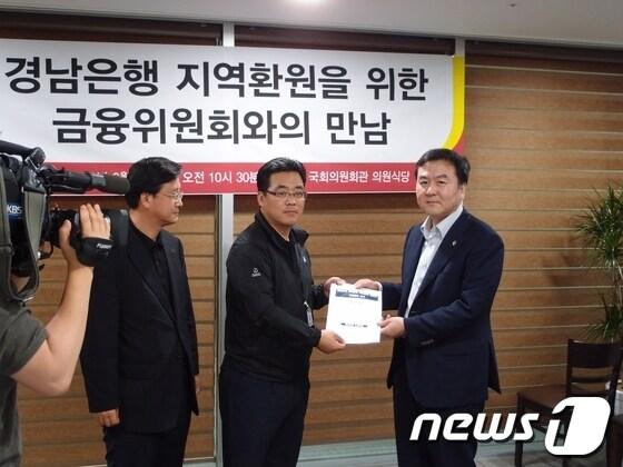 본문 이미지 - 김재경 의원(사진 왼쪽)이 20일 경남은행 지역환원 건의서를 금융위원장에 전달했다 © News1 