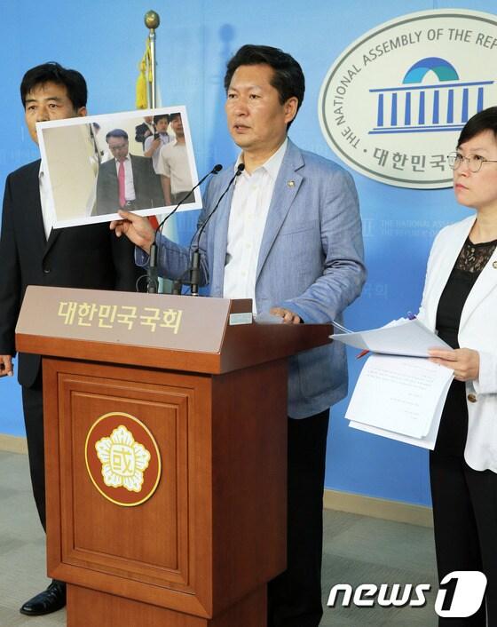 본문 이미지 - 민주당 정청래 정보위원회 간사와 정보위원들이 20일 서울 여의도 국회 정론관에서 가진 기자회견에서 국가정보원 한기범 1차장이 고 노무현 전 대통령의 'NLL 대화록'을 새누리당에 건네주고 국회를 빠져나가는 모습이 담긴 사진을 공개하고 있다. 의원들은 이 자리에서 