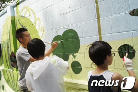 본문 이미지 - 군장병과 북원초 학생들이 학교 담장에 수박을 그려넣고 있다.2013.6.20/뉴스1 © News1 이예지 기자