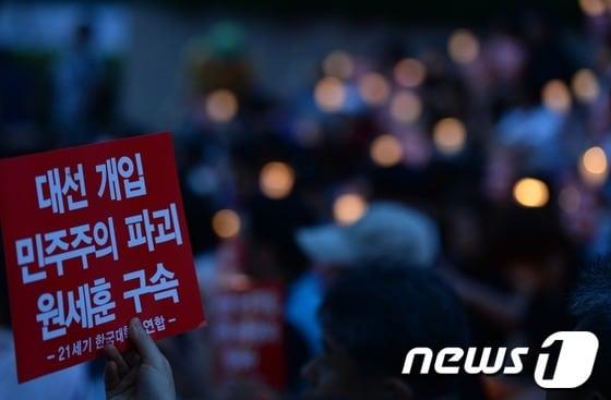 본문 이미지 - 23일 오후 서울 세종로 청계광장 인근에서 진보성향의 대학생·시민단체 주최로 열린 &#39;반값등록금 여론조작과 대선개입 국정원 규탄&#39; 촛불집회에 참가한 한 시민이 &#39;대선개입 민주주의 파괴 원세훈 구속&#39;이라고 적힌 손팻말을 들고 있다. © News1