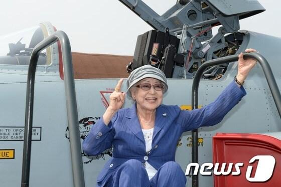 본문 이미지 - 영화 '빨간마후라'의 주인공 최은희(왼쪽)씨가 1일 오후 수원 공군제10전투비행단 활주로에서 F-5전투기를 배경으로 기념촬영하고 있다. 공군제10전투비행단은 이날 조종사의 날을 이틀 앞두고 영화 빨간마후라의 주연배우들을 부대로 초청해 영화 속 장면들을 재연하는 행사를 개최했다. 2013.7.1/뉴스1