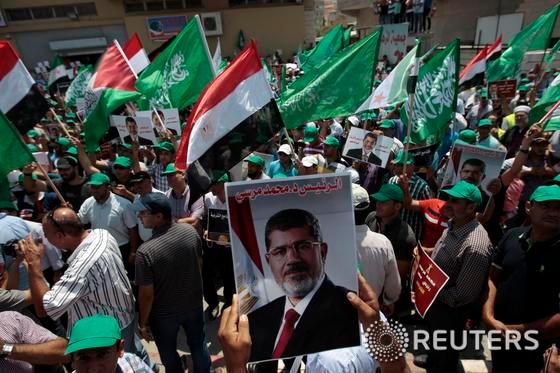 본문 이미지 - 13일(현지시간) 이스라엘 북부 카파르 카나 마을에서 아랍인들이 이집트 군부에 의해 축출된 모하메드 무르시 전 이집트 대통령을 지지하는 시위를 벌이고 있다.  © 로이터=뉴스1 