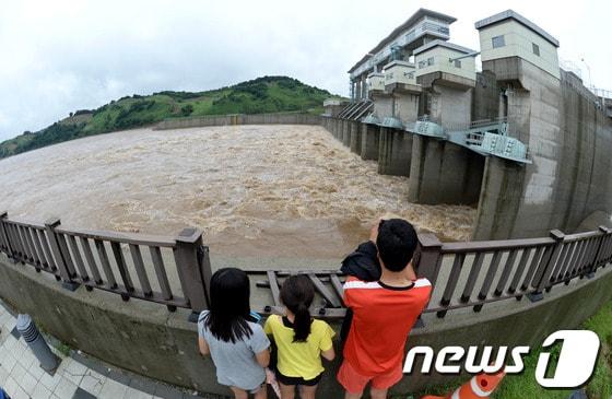 본문 이미지 - 14일 경기도 연천군 군남면 군남댐에서 주민들이 물이 방류되는 모습을 바라보고 있다. 현재 임진강 홍수조절용인 군남댐 저수위가 올라가 13개의 수문을 모두 개방해 물을 방류하고 있다. 2013.7.14/뉴스1 © News1   박세연 기자