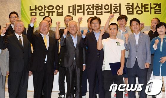 본문 이미지 - 김웅 남양유업 대표(앞줄 왼쪽 두 번째)와 이창섭 피해대리점협의회 회장(앞줄 오른쪽 세 번째)을 비롯한 양측 관계자들과 민주당 의원들이 지난 7월 서울 중구 중림동 LW컨벤션에서 '남양유업 정상화를 위한 공동 선언문' 교환을 축하하며 파이팅을 외치고 있다. © News1 손형주 기자