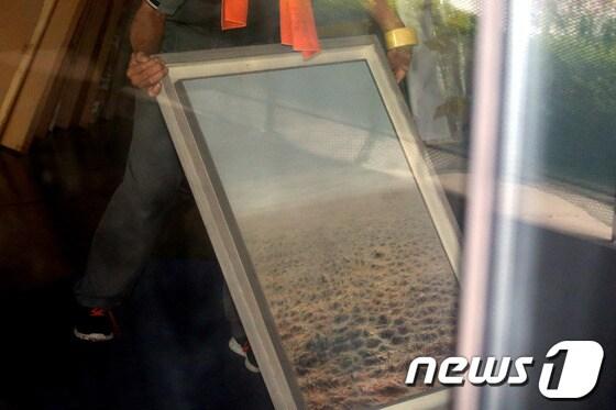 본문 이미지 - 검찰이 전두환 전 대통령 일가에 대한 압수수색을 사흘째 이어가고 있는 18일 오전 전 전 대통령의 장남 전재국씨가 운영하는 경기도 파주시 출판단지 시공사 사옥에서 관계자들이 압수한 미술품을 옮기고 있다. © News1 이광호 기자