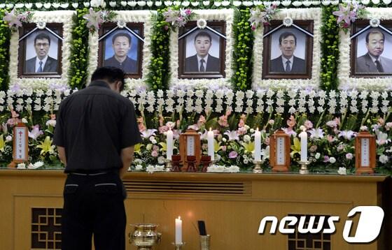 본문 이미지 - 노량진 배수지 수몰사고로 숨진 7명의 희생자들의 합동분향소가 마련된 서울 고려대학교 구로병원 장례식장에서 한 추모객이 고인들을 추모하고 있다. 2013.7.18/뉴스1 © News1   