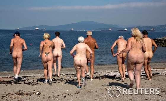 본문 이미지 - 18일(현지시간) 캐나다 밴쿠버의 선셋 비치에서 나체의 남녀들이 바다를 향해 뛰어가고 있다. 이 단체는 이번 주말 열리는 '제 17회 레크비치(Wreck Beach) 누드 달리기' 를 홍보하고 있다. 레크 비치는 자연주의자들과 나체주의자들에게 인기 있는 밴쿠버의 외딴 해변이다. © 로이터=뉴스1  