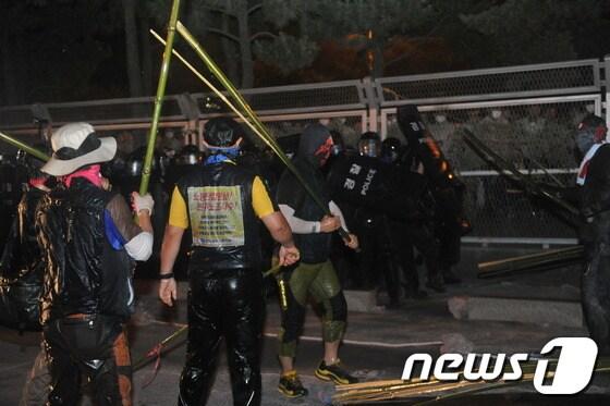 본문 이미지 - 지난 20일 오후 울산 현대자동차 비정규직 철탑농성장에서 희망버스 참가자들, 현대차 사측 관리자와 경찰들 사이에 물리적 충돌이 발생했다. 일부 참가자들이 죽봉을 들고 경찰과 대치하고 있다. © News1 노화정 기자 