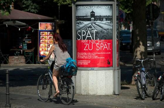 본문 이미지 - 독일 베를린에서 나치 전범을 추적하는 단체인 '사이먼 비젠탈 센터'가 70여년 전 홀로코스트 주범을 찾기위해 부착한 포스터. 포스터는 아우슈비츠 수용소 사진에 