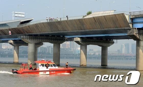 본문 이미지 - 성재기 남성연대 상임대표가 한강으로 투신한 26일 오후 서울 마포대교 아래에서 119 소방대원들과 한강경찰대 등이 수색작업을 벌이고 있다. 성 대표는 전날 한강에 투신하겠다는 글을 올렸으며 이날 오후 3시 15분께 자신의 트위터에 