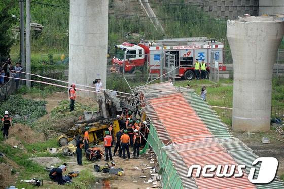본문 이미지 - 방화대교 남단 램프 공사현장에서 상판이 붕괴되면서 중장비가 넘어져 공사장 인부 3명이 깔리는 사고가 발생한 30일 오후 서울 강서구 방화동 사고 현장에서 소방 관계자들이 현장 수습 및 피해자 구조활동을 벌이고 있다. 이 사고로 인부 2명이 사망하고 1명은 부상을 입은 상태다. 2013.7.30/뉴스1 © News1   박정호 기자