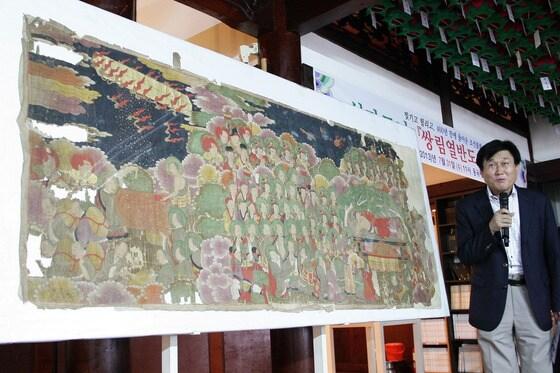 본문 이미지 - 이흥재 전북도립미술관장(사진)이 31일 오전 전북 군산 대한불교 조계종 동국사 대웅전에서 임진왜란 당시 약탈됐다 400여년만인 25일 국내로 들어온 가로형 조선시대(15∼16세기) 불화(탱화)인 '쌍림열반도(가로 225㎝, 세로 93㎝)'에 대해 설명하고 있다.2013.7.31/뉴스1 © News1 김재수 기자
