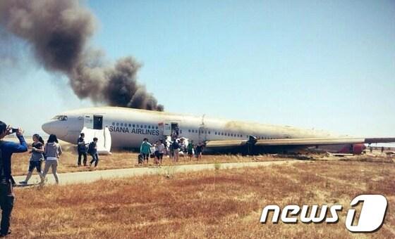 본문 이미지 - 6일(현지시간) 오전 미국 샌프란시스코 공항에서 아시아나항공 214편 B777-200 여객기가 착륙하다 활주로에 충돌하는 사고가 발생했다. 사진은 충돌한 여객기에서 승객들이 탈출하는 모습. 서울에서 출발한 이 사고기의 동체 대부분이 화재로 소실되고 날개와 꼬리 부분이 부러졌으며 승객 292명, 승무원 16명 등 탑승자 308명이 타고 있었던 것으로 알려졌다. (트위터 캡쳐) 2013.7.7/뉴스1 © News1   
