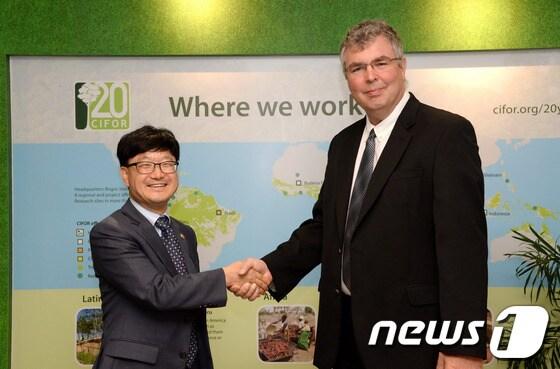 본문 이미지 - 신원섭 산림청장(왼쪽)과 홈그 국제산림연구센터원장(오른쪽)이 인사를 나누는 모습. © News1 