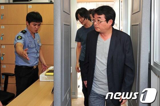 본문 이미지 - 전주지방법원 2호 법정에 들어서고 있는 안도현 시인과 주진우 시사인 기자. 주 기자는 격려 차 안 시인에 대한 첫 공판이 열린 이날 전주지법을 찾았다. 2013.8.1/뉴스1 © News1 김대웅 기자