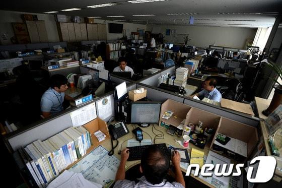 본문 이미지 - 2013년 8월 원자력발전소와 화력발전소 가동 중단 등으로 블랙아웃이 우려되면서 세종로 정부서울청사 내 행정안전부 직원들이 실내등을 끈 채 업무를 보고 있다. 2013.8.12/뉴스1