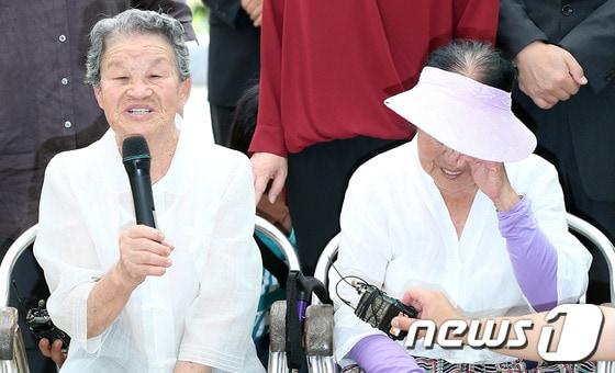 본문 이미지 - 일본군 '위안부' 피해자인 고(故) 이용녀 할머니 안치식이 열린 13일 오후 경기도 광주 퇴촌면 나눔의 집에서 박옥선 할머니가 고인을 향한 추모의 말을 남기자 이옥선 할머니(오른쪽)가 눈물을 훔치고 있다. 1926년 경기 여주에서 태어나 16살 때 미얀마에서 일본군 성노예로 갖은 고초를 겪었던 이용녀 할머니는 지난 2000년 도쿄에서 열린 성노예전범 국제법정에 참석해 증언하는 등 일본군의 만행을 세상에 알리는데 앞장섰다. 할머니가 세상을 떠남에 따라 생존해 있는 위안부 피해 할머니는 57명(해외거주 6명)으로 줄었다. 2013.8.13/뉴스1 © News1   한재호 기자