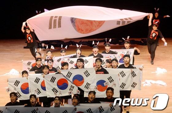 본문 이미지 - 15일 광주시 남구 빛고을문화관에서 열린 광복절 행사에 광주시립소년ㆍ소녀 합창단원들이 쿠바 사회주의 혁명가인 '체 게바라'가 그려진 옷을 입고 공연을 펼쳐 논란이 되고 있다/사진제공=광주일보 2013.8.16 /뉴스1 © News1 