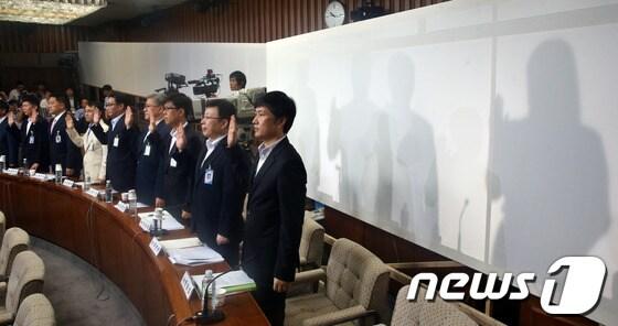 본문 이미지 - 19일 오전 서울 여의도 국회에서 열린 국가정보원 댓글 의혹 사건 등의 진상규명을 위한 국정조사 2차 청문회에서 국정원 댓글 사건 당사자인 국정원 여직원 김모씨 등이 신변보호를 위해 설치된 가림막 뒤에서 선서를 하고 있다. 2013.8.19/뉴스1 © News1   송원영 기자