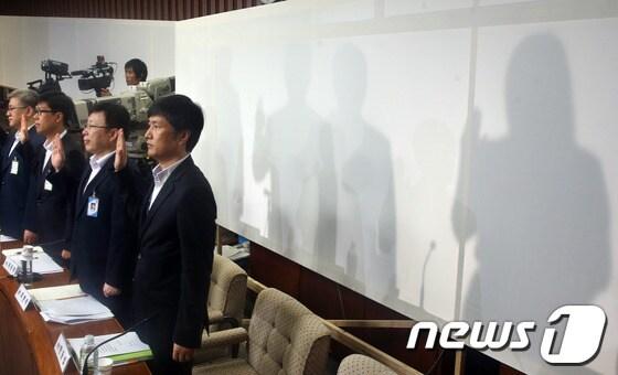 본문 이미지 - 19일 오전 서울 여의도 국회에서 열린 국가정보원 댓글 의혹 사건 등의 진상규명을 위한 국정조사 2차 청문회에서 국정원 댓글 사건 당사자인 국정원 여직원 김모씨 등이 신변보호를 위해 설치된 가림막 뒤에서 선서를 하고 있다. 2013.8.19/뉴스1 © News1   송원영 기자