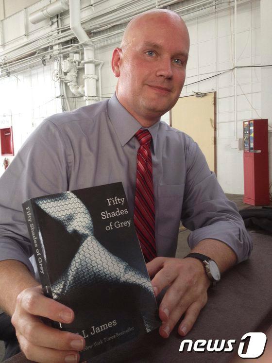 본문 이미지 - 21일(현지시간) '엄마들의 포르노'로 유명한 영국 소설가 E.L. 제임스의 소설 '그레이의 50가지 비밀'을 들고 있는 제임스 코넬 변호사. 코넬은 자신의 의뢰인이자 관타나모 수용소에 수감중인 9·11테러 혐의자 아마르 알 발루치가 교도관이 건넨 이 소설이 가진 사회적인 이미지를 모른 채 법정에 들어갔다가 피해를 입었다고 주장하고 있다.© 로이터=News1 