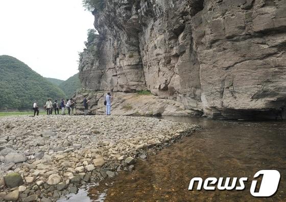 본문 이미지 - 지난 8월 30일 오전 울산시 울주군 언양읍 반구대암각화 현장에서 국립문화재연구소의 발굴조사를 위한 개토제를 앞두고 취재진들이 암각화를 촬영하고 있다. 올 여름 가뭄으로 암각화 앞 대곡천이 바닥을 훤히 드러내고 있다. 2013.8.30/뉴스1 © News1 노화정 기자
