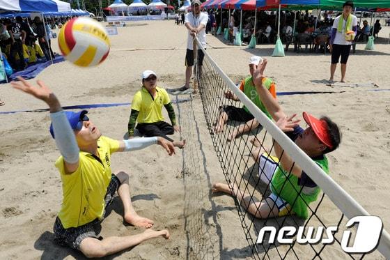 본문 이미지 - 6일 오전 광안리해수욕장에서 열린 '제16회 장애인한바다축제'에서 참가 선수들이 비치발리볼 경기를 하고 있다. 이번 축제는 '파도를 넘어 희망으로'를 주제로 전국장애인비치발리볼대회, 한바다 물놀이, 팔씨름대회, 닭싸움대회, 투호, 해변노래자랑, 페이스페인팅 등이 펼쳐진다. 2013.8.6/뉴스1 © News1 전혜원 기자