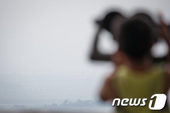 본문 이미지 - 정부가 개성공단 입주기업들에 대한 경협 보험금을 지급하기로 결정한 지난 7일 오후 경기도 파주 도라전망대를 찾은 관광객들이 망원경을 통해 짙은 안개에 싸인 개성공단을 바라보고 있다. 2013.8.7/뉴스1 © News1   유승관 기자