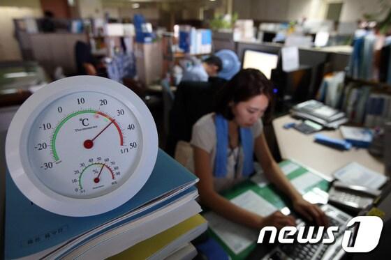 본문 이미지 - 30도가 넘는 사무실에서 직원들이 실내등과 냉방기 사용을 절제하며 업무를 보는 모습.  © News1   한재호 기자 