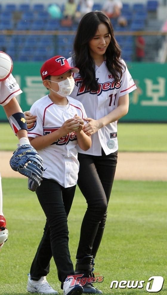 본문 이미지 - 배우 한가인이 1일 오후 광주 무등야구장에서 열린 '2013 한국야쿠르트 세븐 프로야구' 기아타이거즈와 NC다이노스의 경기에 앞서 시구도우미로 나서고 있다. 한가인은 소아암을 앓다가 올해 1월 완쾌 판정을 받은 박철민 어린이의 시구도우미로 마운드에 올랐다. (기아타이거즈 제공) 2013.9.1/뉴스1 © News1   