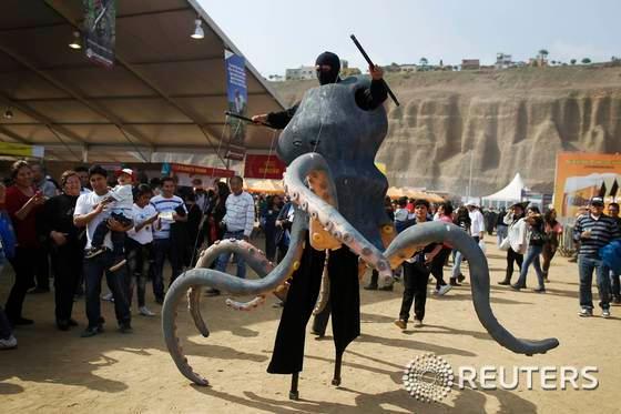 본문 이미지 - 12일(현지시간) 페루 수도 리마에서 열린 미스투라 미식 축제에 문어 복장을 한 댄서가 퍼포먼스를 벌이고 있다. 페루 음식을 홍보하기 위한 이 축제엔 국내외 요리사들이 참가하고 있으며, 15일까지 계속된다. 이 행사는 농민, 피스코(페루산 브랜디) 생산자, 제빵업자, 요리사, 제과점, 요리스쿨, 음식 소매업자, 음식관련산업 같은 미식 체인에서 일하는 여러 실무자들을 끌어모은다. © 로이터=뉴스1  
