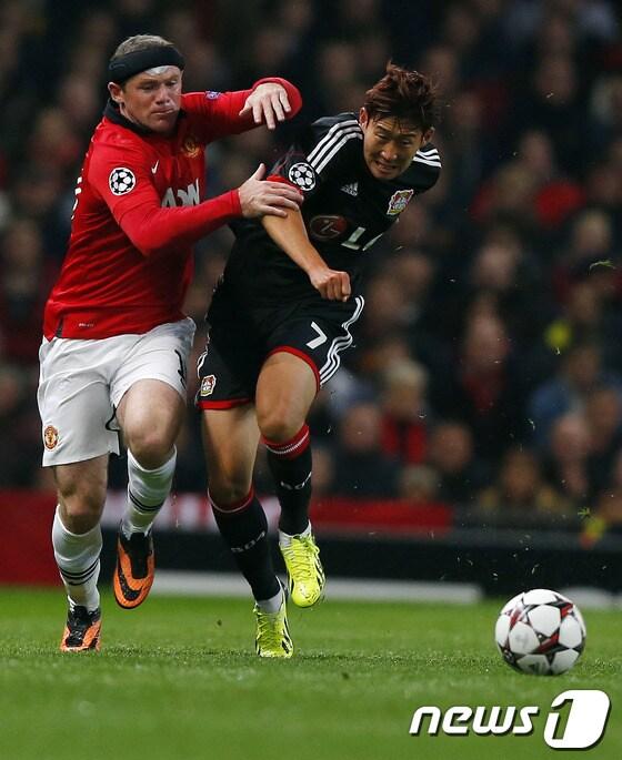 본문 이미지 - 손흥민&#40;21·레버쿠젠&#41;이 18일&#40;한국시간&#41; 영국 맨체스터의 올드트래포드에서 열린 2013-2014 유럽축구연맹&#40;UEFA&#41; 챔피언스리그 A조 1차전 맨체스터 유나이티드와의 경기에 선발 출전해 웨인 루니&#40;왼쪽&#41;와 볼 다툼을 하고 있다.© AFP=News1