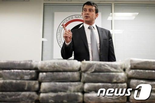 본문 이미지 - 21일(현지시간) 마뉘엘 발스 프랑스 내무장관이 카라카스발 파리행 에어 프랑스에서 적발한 코카인 1.3톤을 담았던 30개의 가방을 공개하며 기자회견을 열고 있다. © AFP=뉴스1  