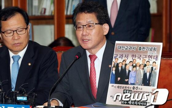 본문 이미지 - 유기홍 민주당 역사교과서 친일미화 왜곡대책위원회 위원장이 26일 오전 서울 여의도 국회에서 열린 24시 비상국회 운영본부회의에서 박근혜 대통령이 2008년에 대안교과서 출판기념회 참석한 사진을 들어보이며 발언하고 있다. 2013.9.26/뉴스1 © News1   허경 기자