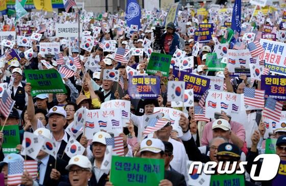 본문 이미지 - 재향군인회 등 보수성향 시민단체 회원들이 집회에서 태극기와 성조기를 함께 흔들고 있다. /뉴스1 © News1 박지혜 기자