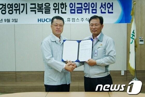 본문 이미지 - 여수국가산단 내 휴켐스 최규성 대표이사(왼쪽) 와 김재학 노조위원장(오른쪽)이 임금협상 위임장에 서명한 후 악수를 하고 있다.© News1 김상렬 기자