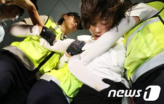 본문 이미지 - 통합진보당 김재연 의원이 4일 저녁 국회 의원회관에서 이석기 의원 강제구인에 나선 국정원 직원들과 대치하다 여경들에 의해 끌려나오고 있다. 2013.9.4/뉴스1 © News1   오대일 기자