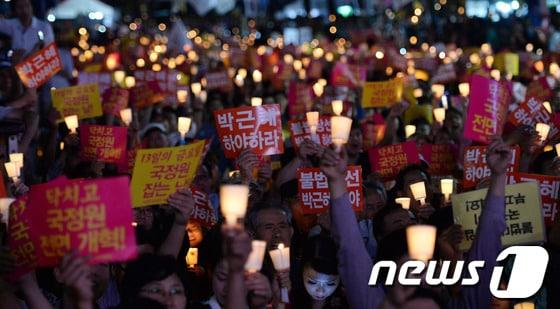 본문 이미지 - 지난 9월7일 오후 서울 청계광장에서 열린 11차 국정원 대선개입 규탄 범국민 촛불집회에서 참석자들이 국정원과 박근혜 정부를 규탄하는 구호를 외치고 있다. © News1 양동욱 기자