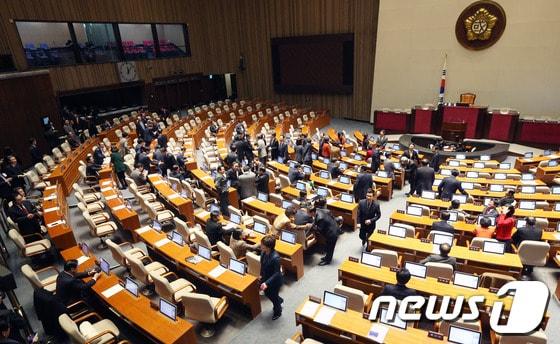 본문 이미지 - 새해 예산안 연내 처리가 무산된 1일 새벽 서울 여의도 국회의사당 본회의장에서 의원들이 회의장 내 시계가 자정을 넘기자 서로 악수를 나누며 새해 인사를 하고 있다. 국회는 2년 연속이자 헌정 사상 두 번째로 해를 넘겨 예산안을 처리하는 불명예를 기록하게 됐다. 2014.1.1/뉴스1 © News1 오대일 기자