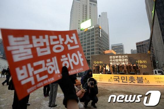본문 이미지 - 11일 서울광장에서 열린 국가기관의 대선개입 의혹과 수사방해에 대한 진상 규명을 위한 국정원 시국회의 촛불집회에서 참석자들이 피켓을 들고 있다. 2014.1.11/뉴스1 © News1   안은나 기자