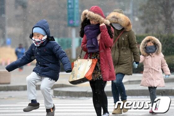본문 이미지 - 서울 광화문 세종로 네거리를 지나는 시민들이 눈을 맞으며 도로를 횡단하고 있다./뉴스1 © News1 정회성 기자