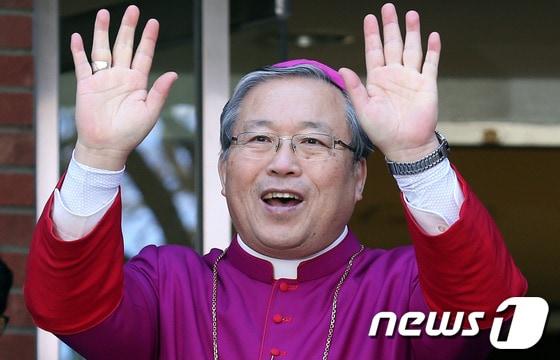 본문 이미지 - 한국 세 번째 추기경으로 임명된 염수정 서울대교구장이 13일 오전 서울대교구청 주교관 앞마당에서 열린 임명축하식에서 손을 들어 인사하고 있다. 염 대주교는 오는 2월22일 로마 바티칸에서 열릴 예정인 추기경 서임식에서 한국의 세 번째 추기경으로 서임된다. 2014.1.13/뉴스1 © News1   한재호 기자