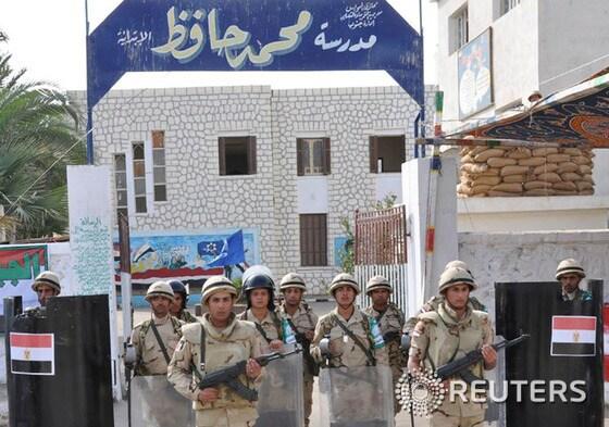 본문 이미지 - 국민투표소로 활용될 한 학교를 경계하고 있는 이집트 군인들. © 로이터=뉴스1 