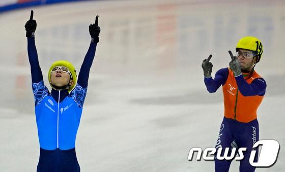 본문 이미지 - 안현수&#40;29·러시아 명 빅토르안&#41;가 20일&#40;한국시간&#41; 열린 2014 유럽 쇼트트랙 선수권 5000m계주에서 금메달을 확정지은 뒤 두 손을 번쩍 들어올리며 기쁨을 드러내는 가운데, 2위로 들어온 싱키 크네흐트&#40;네덜란드&#41;가 &#39;손가락 욕&#39;을 하고 있다. © AFP=News1 
